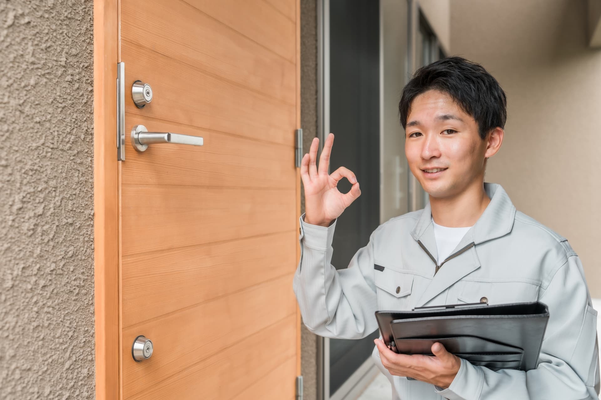 玄関ドアをチェックする工務店の男性作業員